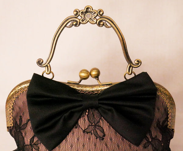 Black lace over blush satin handbag with black bow and antique brass frame with handle