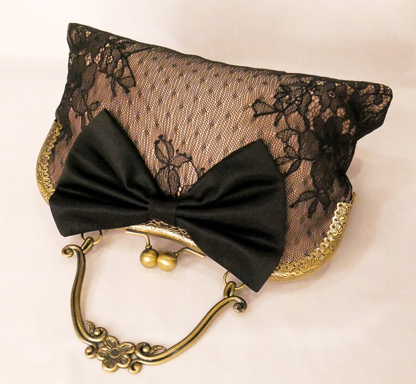 Black lace over blush satin handbag with black bow and antique brass frame with handle