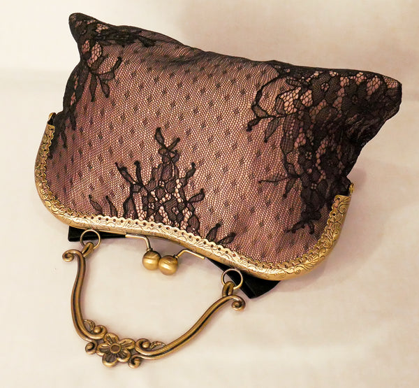 Black lace over blush satin handbag with black bow and antique brass frame with handle
