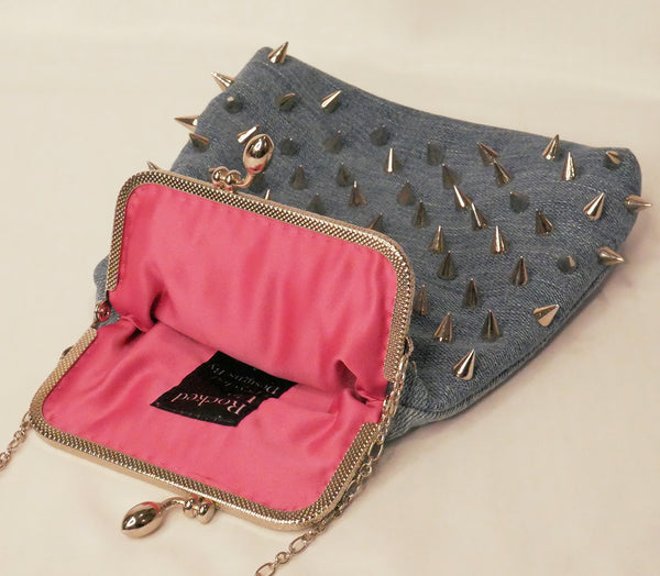 Blue denim handbag with silver studs and a silver star patch, with pink satin lining and a silver metal frame and chain wrist strap