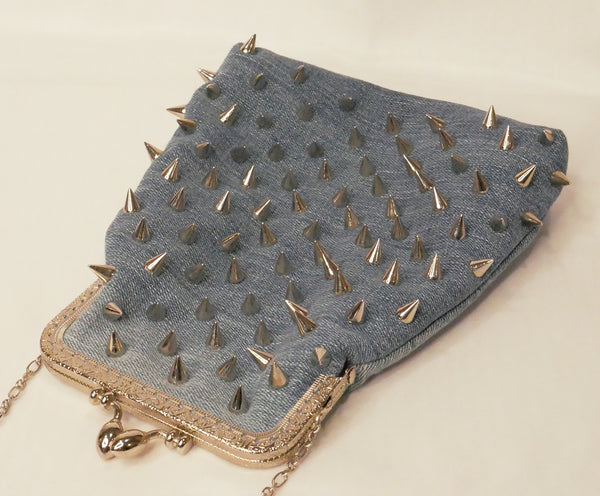 Blue denim handbag with silver studs and a silver star patch, with pink satin lining and a silver metal frame and chain wrist strap