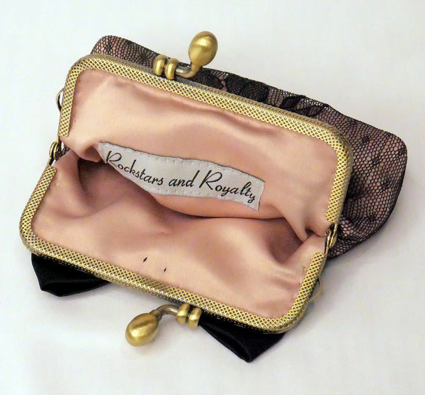 Small purse made of blush satin with a black lace overlay, black satin bow and antique brass frame.